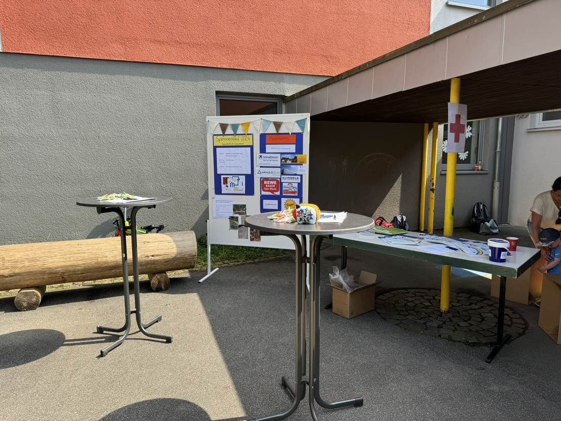 Infostand mit Sponsorentafel und Stehtischen auf dem Schulhof